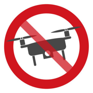 No Drone Zone sign with a red circle and diagonal line over a black drone silhouette.
